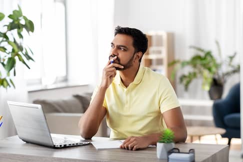 A man sitting in his home office thinking.