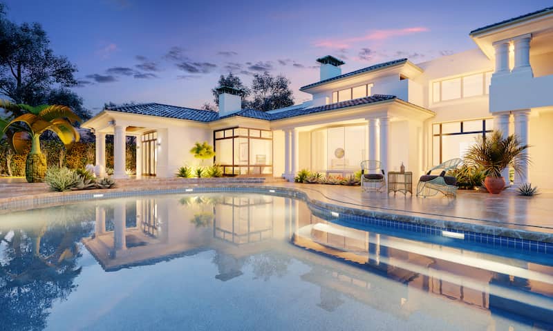 Contemporary mansion with luxury pool and palm trees in landscape.