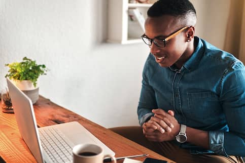 Young man looking at computer screen thinking.