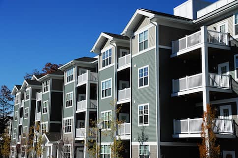 Modern apartment complex against blue sky.