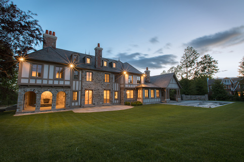 Exterior of large tudor style hoe at night.