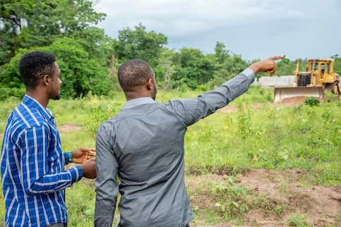 Two young men surveying raw land.