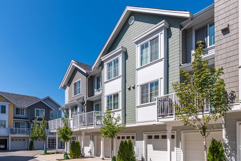 Three-story apartment building with large windows.