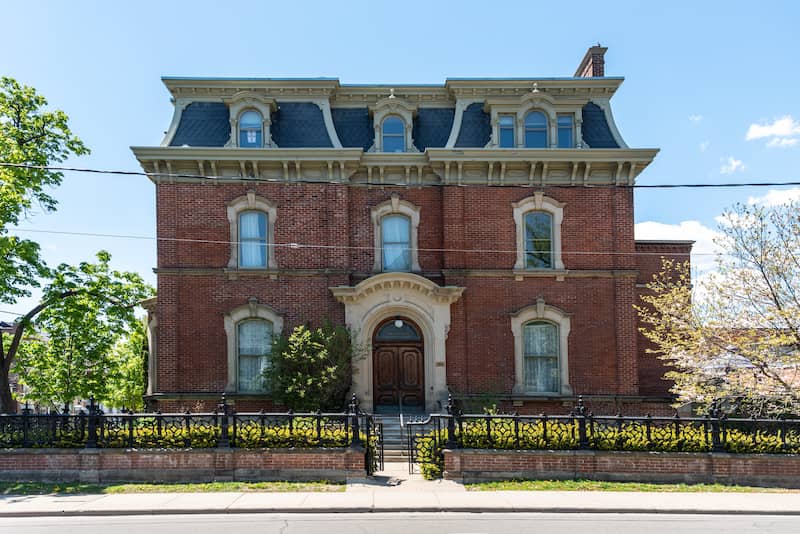 Brick second empire home with arched doors and windows.