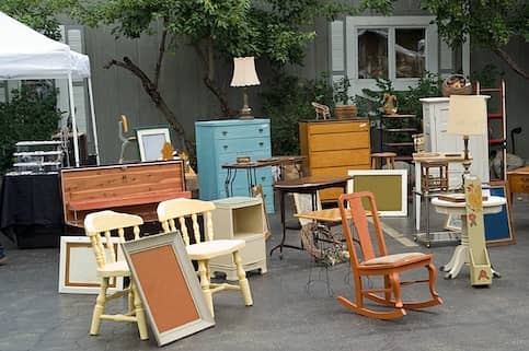 Collection of furniture for sale in front of home.