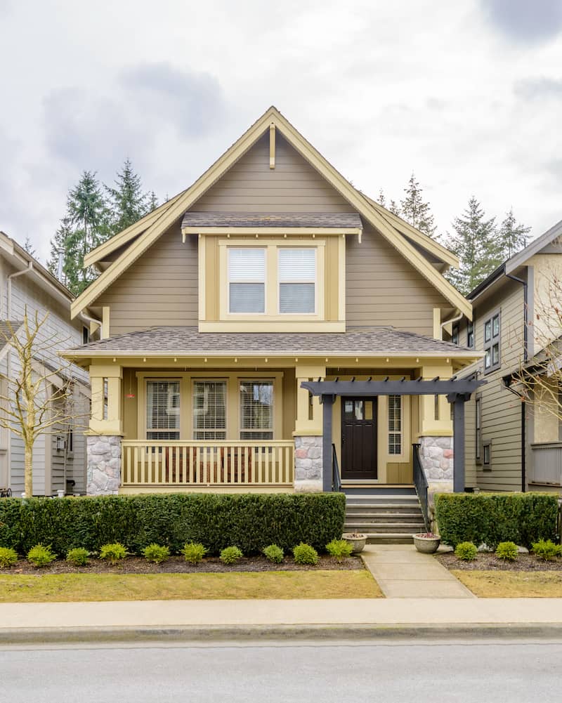 Tan and yellow trimmed small bungalow craftsman house.