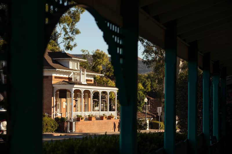 A brick Mission Revival house with white columns in California.