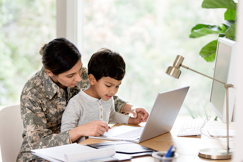 Veteran with their son on computer