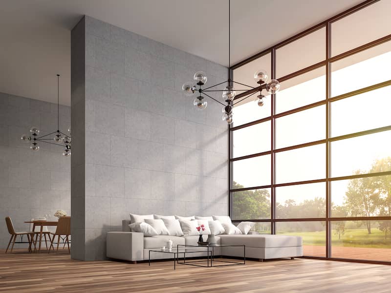 Modern and minimalistic living room with a floor to wall window and high ceilings.