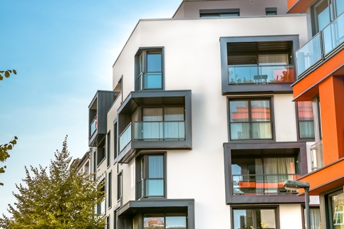 Orange and white condo building with balconies.