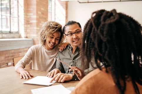 Couple sitting at table going over closing papers with notary