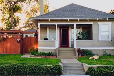 Small white ranch style house with covered porch.