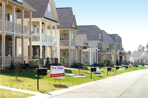 Row of homes on a street with for sale sign