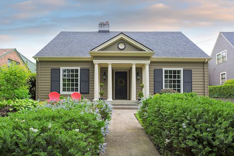 front of house with bushes on the side of walkway