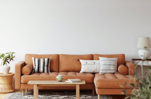 Burnt orange chaise living room set with wicker coffee table.