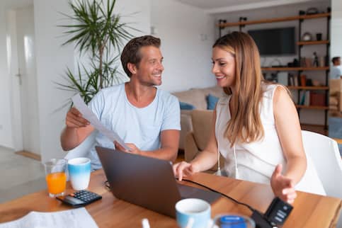 couple looking at while looking having breakfast at home