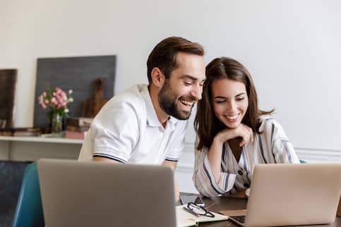 couple sitting looking at their laptops together