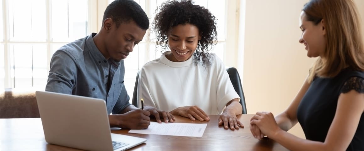 Couple signing documents with an agent