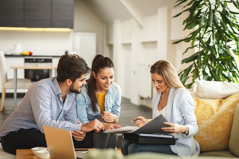 Young couple talking to their real estate agent.