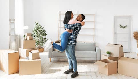 Couple hugging who just relocated into a new home.