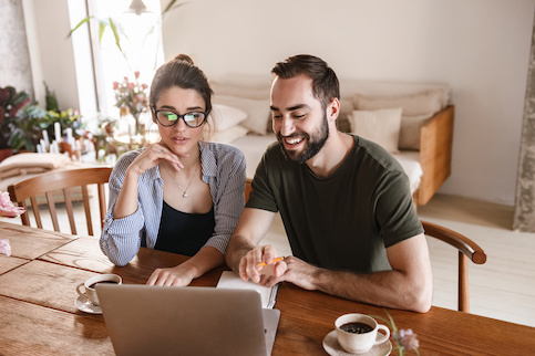 Couple With Coffee Working On Laptop