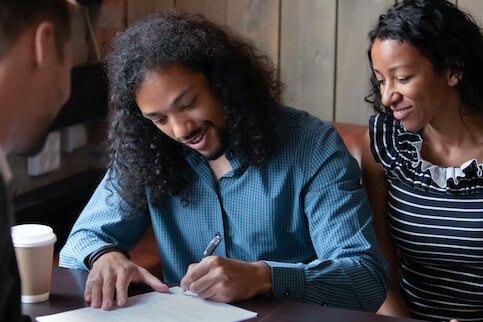 Couple signing paperwork.