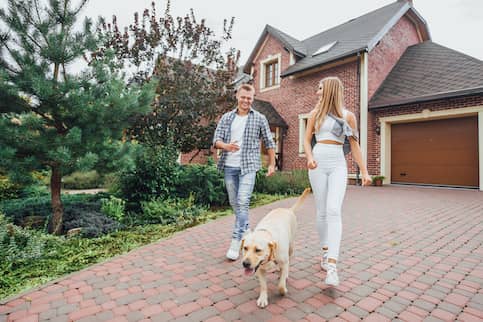 Couple leaving house with dog.