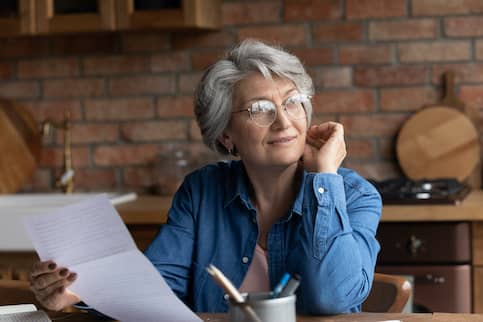 Elder woman thinking while holding a document