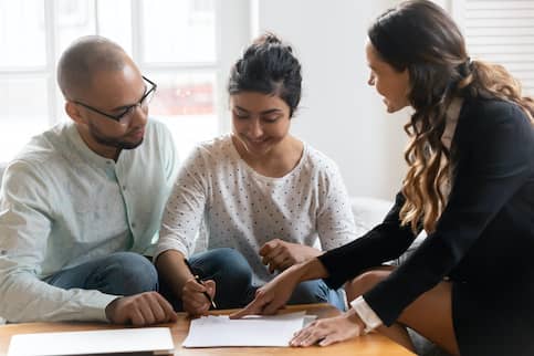 Couple signing documents with an agent