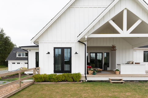 Large white house with fenced yard.