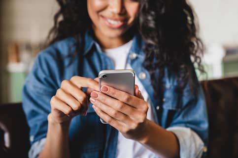 Young woman searching on phone for realtor.