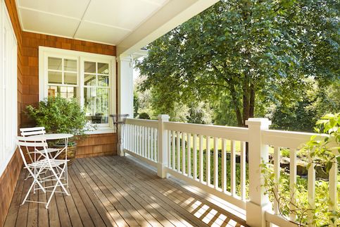 Porch with chair and railing on it. 