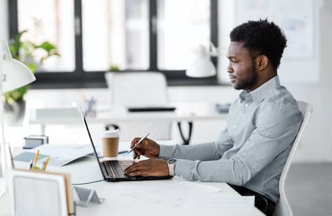 man at laptop in bright office