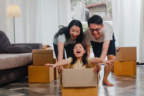 Young family having fun moving into their new house.