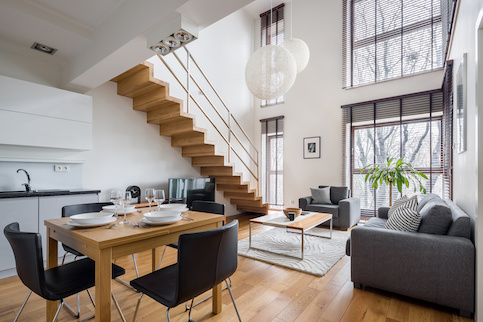 Hip city townhouse or apartment with open staircase in living room.