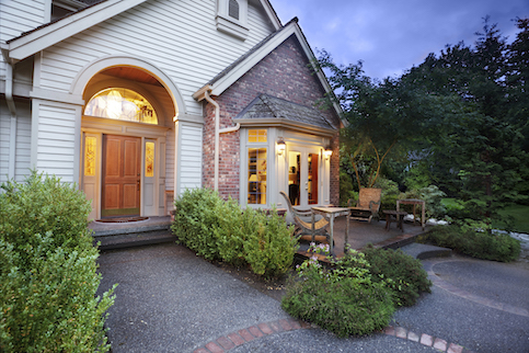 Front porch of a house with lights on in the house.