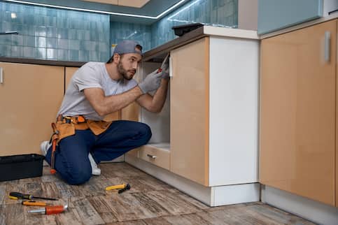 Homeowner Working On Kitchen Cabinets