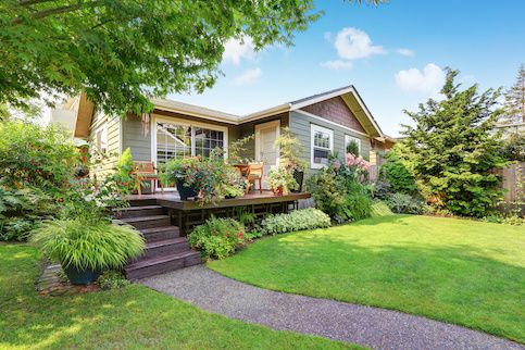 House with large deck and lots of planters.