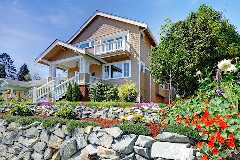 house on hill with flowers in yard