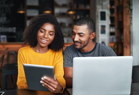 couple on couch searching ipad and laptop