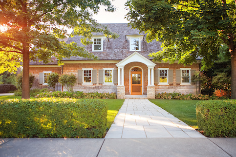 Two story home with hedge fencing.