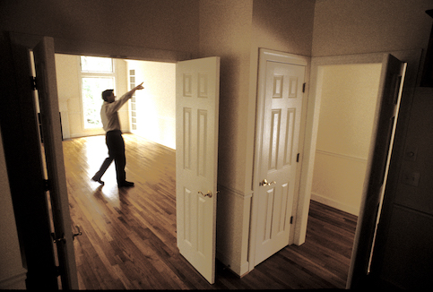 Man leading a tour through an empty house. 
