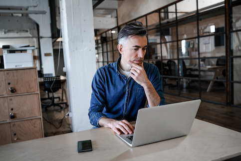 Man in office using laptop.