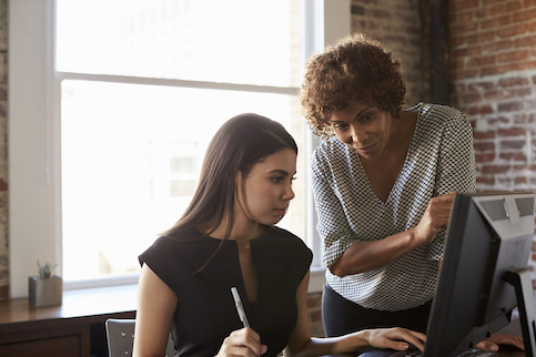 Mentor helping younger coworker.