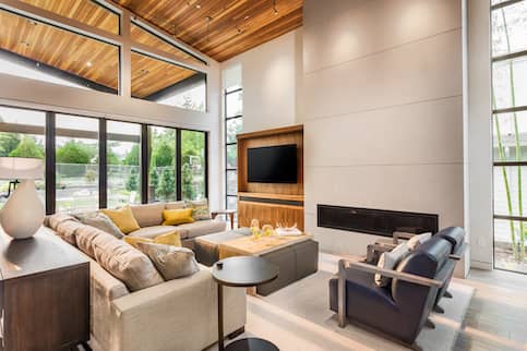 Modern luxury living room interior with vaulted ceilings and fireplace.