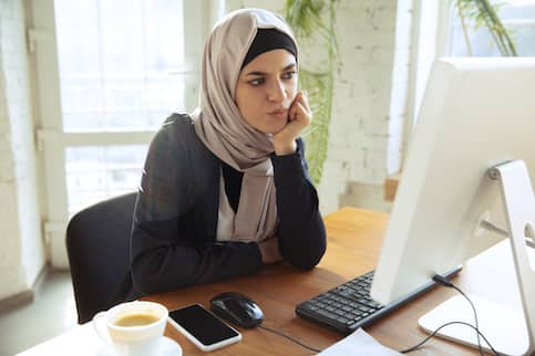 Woman with hijab figuring out mortgage payment schedule.