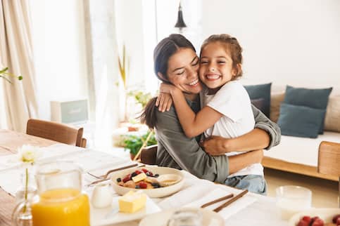 Mother and daughter eating breakfast in refinanced home with seasonal income.