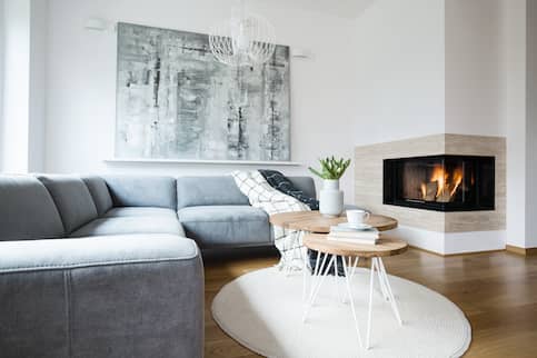 Nordic style living room interior with round hanging light and fireplace.