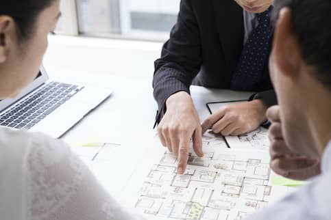 couple and agent looking at real estate plans