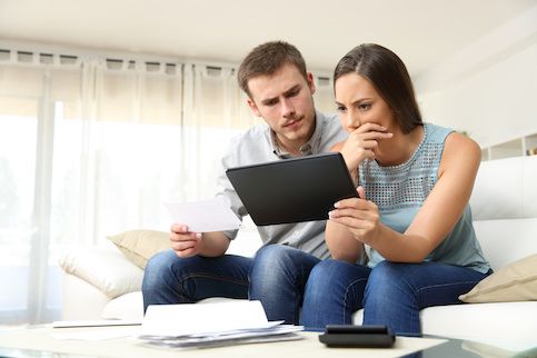 Couple looking concerned while checking finances.